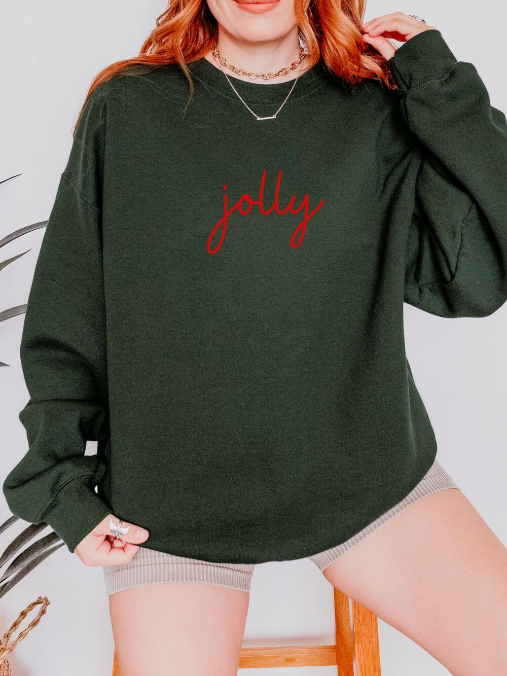 Jolly_Red_Script_Forest Jolly Red Script Heavy Blend Women's Crewneck Embroidered Christmas Holiday Sweatshirt - Image 1