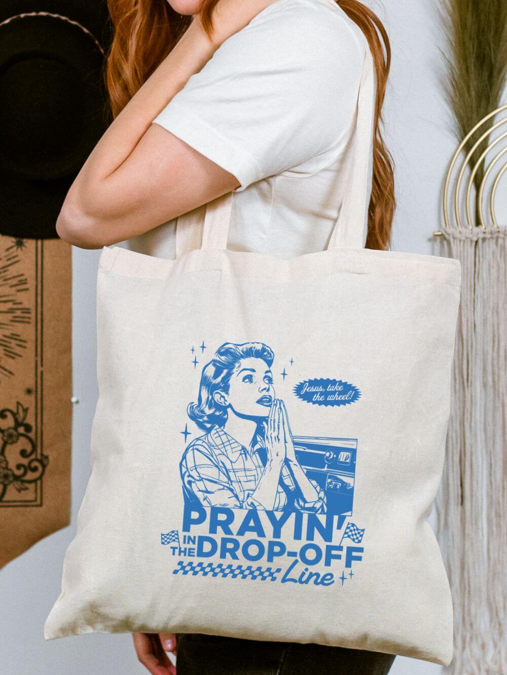 Prayin_in_the_Drop_Off_Line_Tote Prayin' in the Drop-Off Line Christian Mom Cotton Canvas Tote Bag - Image 1
